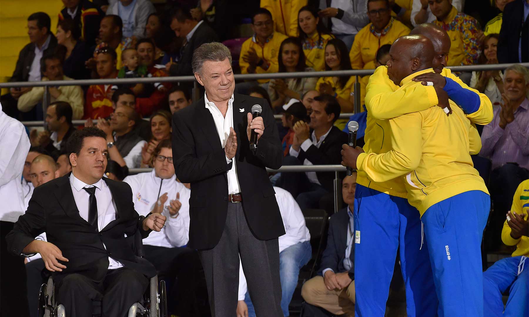 Dos jugadores ruandeses de voleibol sentado y que antes fueron combatientes de bandos distintos en el conflicto de su país, dan una muestra de reconciliación con un abrazo, en presencia del Presidente Santos.