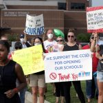 Un reportero de televisión filma frente a simpatizantes de la decisión del distrito escolar del Condado de Cherokee de reabrir las escuelas durante la pandemia de coronavirus. Canton, Georgia, EEUU. REUTERS/Dustin Chambers
