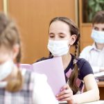 Pupils wearing protection mask to prevent virus during lesson in classroom