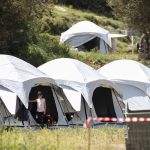 Una niña fuera de una tienda en un campo de refugiados e inmigrantes en Grecia. REUTERS/Elias Marcou