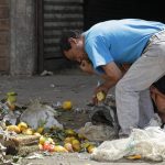Un hombre busca verduras y frutas sobrantes en un mercado de Bogotá, REUTERS/John  Vizcaino