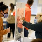 Una trabajadora electoral presenta los detalles de una votante a través de un separador plástico para protegerse del coronavirus en el último día de votación adelantada en persona para las elecciones presidenciales de Estados Unidos en Cornelius, Carolina del Norte, 31 de octubre de 2020. REUTERS/Jonathan Drake