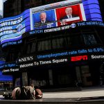 Una persona duerme frente a una pantalla que muestra la cobertura de las elecciones en Times Square, Manhattan, Nueva York, Estados Unidos. 6 de noviembre de 2020. REUTERS/Andrew Kelly
