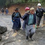 Un hombre carga a un niño sobre la espalda tras el paso de la tormenta Eta, en San Cristóbal Verapaz, Guatemala.noviembre de 2020. REUTERS/Luis Echeverria