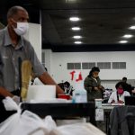 Personas continúan con el recuento de votos en TCF Center. REUTERS/Shannon Stapleton