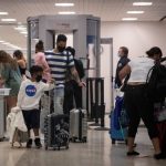 Una familia usa mascarillas al pasar la seguridad en la Terminal A del Aeropuerto Intercontinental George Bush en medio del brote de la enfermedad coronavirus (COVID-19) en Houston, Texas, Estados Unidos. 21 de julio de 2020. REUTERS/Adrees Latif/