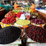 Personas trabajan en un puesto de frutas y vegetales en Cali, REUTERS/Jaime Saldarriaga