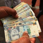 Un trabajador de una casa de cambio sostiene billetes de soles peruanos en Lima, Perú. REUTERS/Mariana Bazo