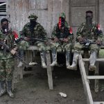 Guerrilleros del Ejército de Liberación Nacional (ELN) descansan frente a una casa cerca al río San Juan, en las selvas del departamento del Chocó. REUTERS/Federico Ríos