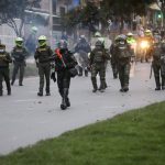 Agentes de policía se posicionan frente a manifestantes que participan en una protesta contra el Gobierno en Bogotá, REUTERS/Luisa González