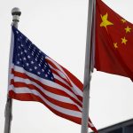 Las banderas de China y Estados Unidos frente al edificio de una empresa estadounidense en Pekín, China. REUTERS/Tingshu Wang