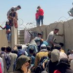 Un hombre trata de meter a una niña en el aeropuerto internacional  Hamid Karzai en Kabul, Afganistán, 16 de agosto del 2021. REUTERS/Stringer