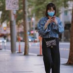 Una mujer con mascarilla camina por las calles Sidney (Australia), durante el confinamiento por coronavirus. Foto Unsplash/Kate Trifo
