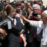 El Papa saluda a la hija de un miembro de la orquesta tras la Audiencia General. Foto: Vatican Media.