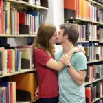 Heterosexual couple kissing in a library